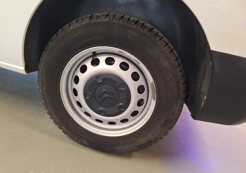 Gros plan sur la roue avant droite blanche d'un Citroën Jumpy 2.0 BlueHDi 120 Club avec jante acier et logo Citroën.