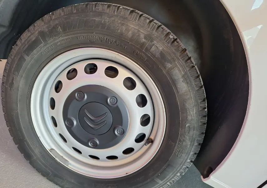 Gros plan sur la roue avant droite blanche d'un Citroën Jumpy 2.0 BlueHDi 120 Club de 2020 avec jante acier et logo Citroën.