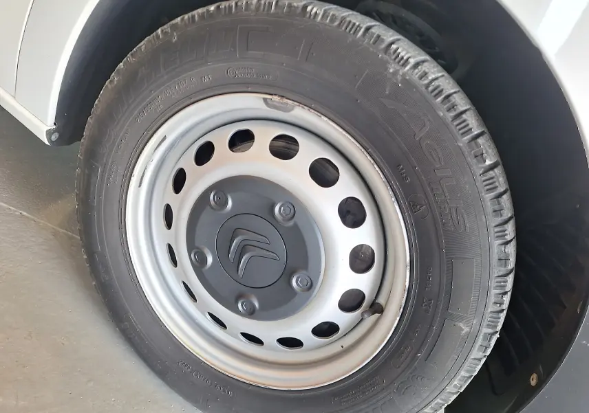 Gros plan sur la roue avant gauche blanche du Citroën Jumpy 2.0 BlueHDi 120 Club avec jante acier et logo Citroën.