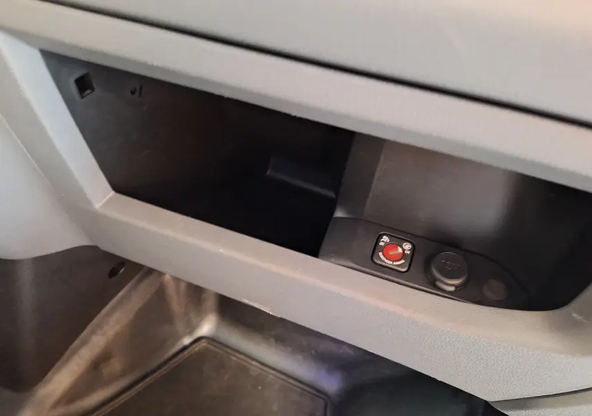 Détail du rangement intérieur avec prise 12V et commande rouge dans un Citroën Jumpy blanc 2020.