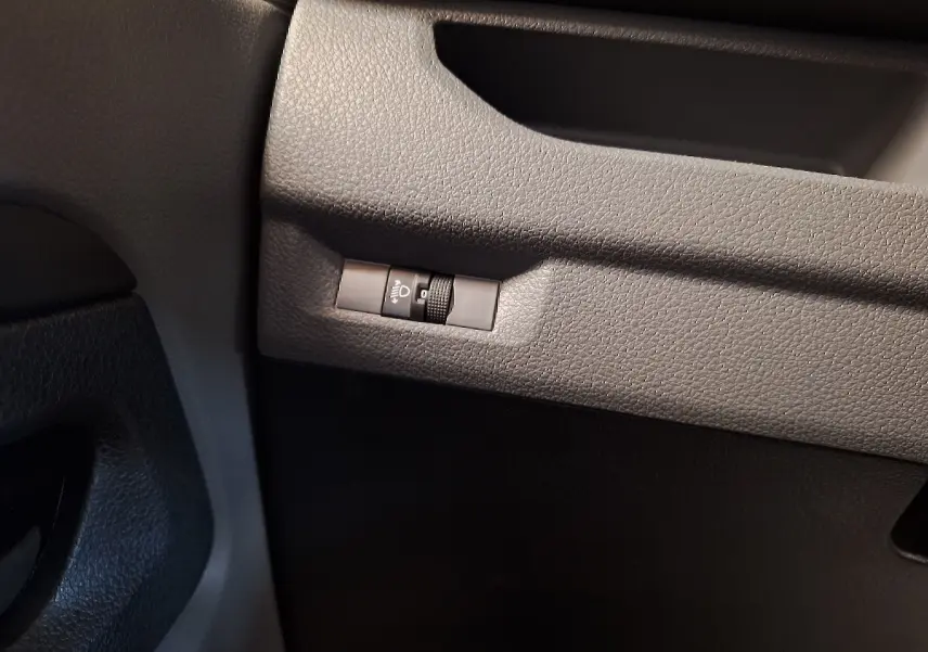 Gros plan sur le réglage de l'intensité des phares dans l'habitacle noir du Citroën Jumpy blanc 2020.