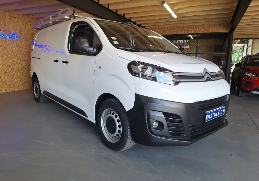 Vue 3/4 avant d'un utilitaire blanc Citroën Jumpy 2.0 BlueHDi 120 avec galerie de toit en intérieur.