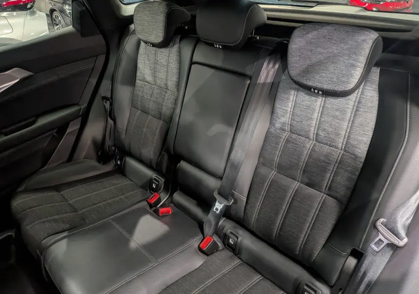 Vue rapprochée des sièges arrière en cuir noir et tissu gris du Renault Austral 2024, soulignant les ceintures de sécurité et appuie-têtes.