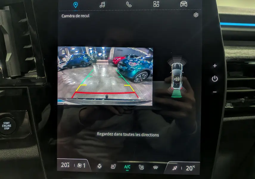 Écran central du Renault Austral 2024 affichant la caméra de recul et l'aide au stationnement en intérieur showroom.