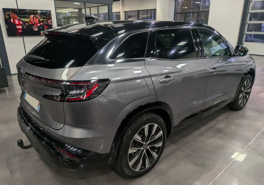 Renault Austral gris schiste avec toit noir, vue 3/4 arrière droit en intérieur, jantes alliage bicolores visibles.