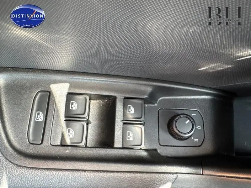 Gros plan sur les commandes des vitres électriques et réglage des rétroviseurs côté conducteur d'une Audi A1 Sportback noir Mythic.