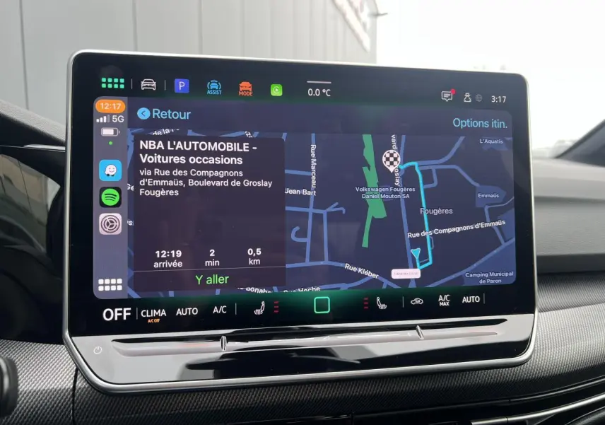 Écran tactile central de la Volkswagen Golf VIII noir affichant la navigation et les commandes climatisation.