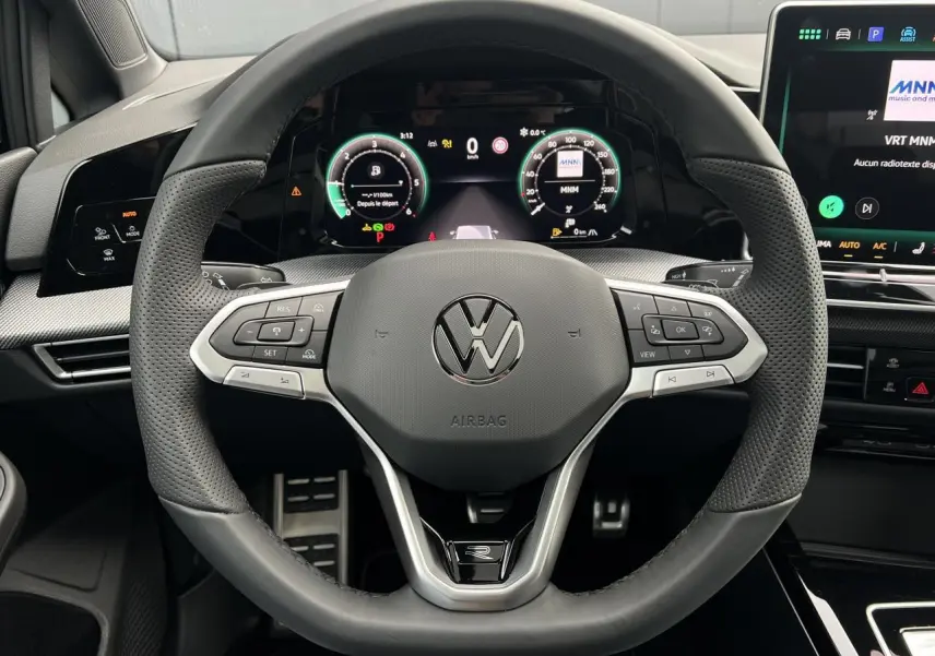 Vue rapprochée du volant sport cuir multifonctions de la Volkswagen Golf VIII R-Line avec tableau de bord numérique.