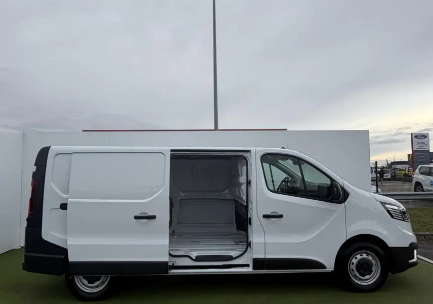 Vue latérale droite d'un Renault Trafic Fourgon blanc Glacier avec porte coulissante ouverte montrant l'espace de chargement vide.