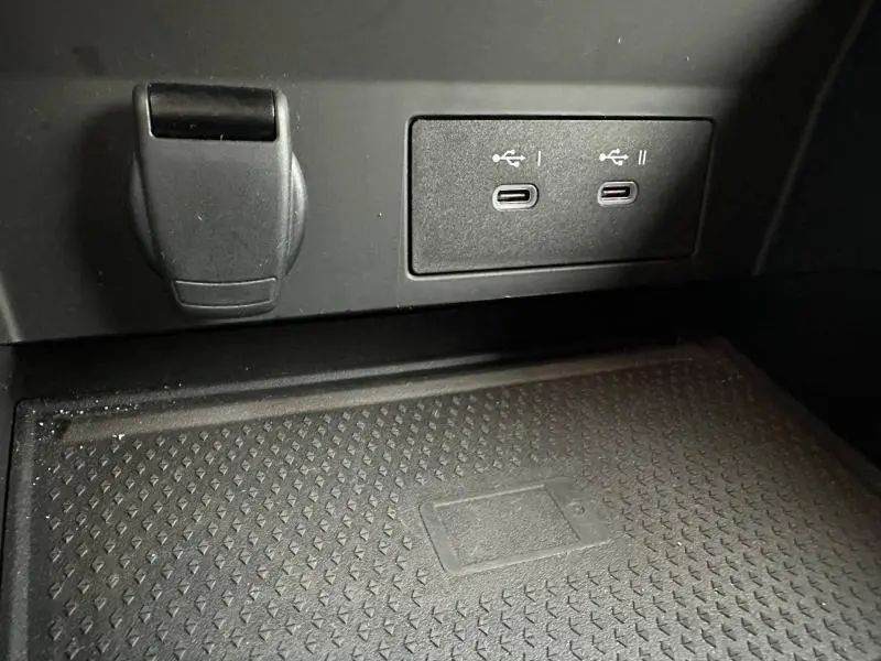 Gros plan sur la console centrale du Renault Captur 2025 montrant deux ports USB-C et une prise 12V, surface antidérapante noire.