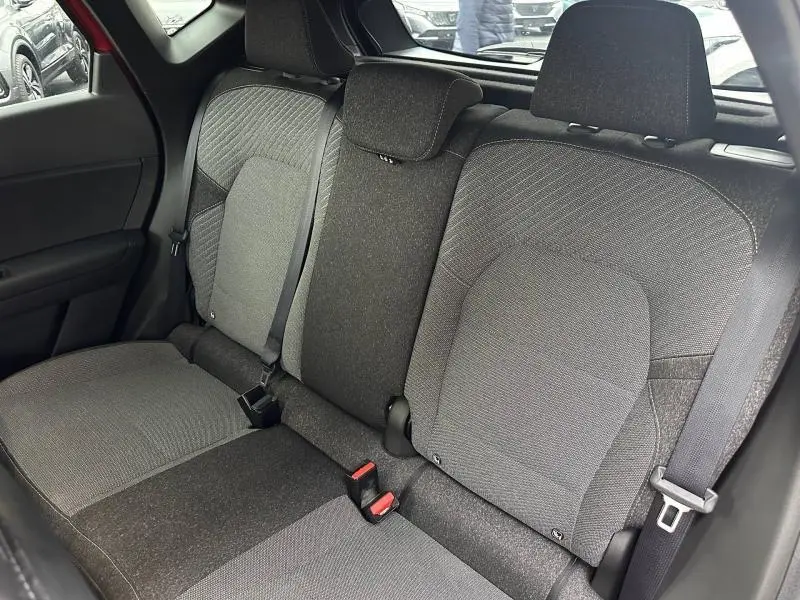 Vue intérieure sur les sièges arrière gris foncé du Renault Captur 2025, avec ceintures de sécurité et appuie-têtes visibles.