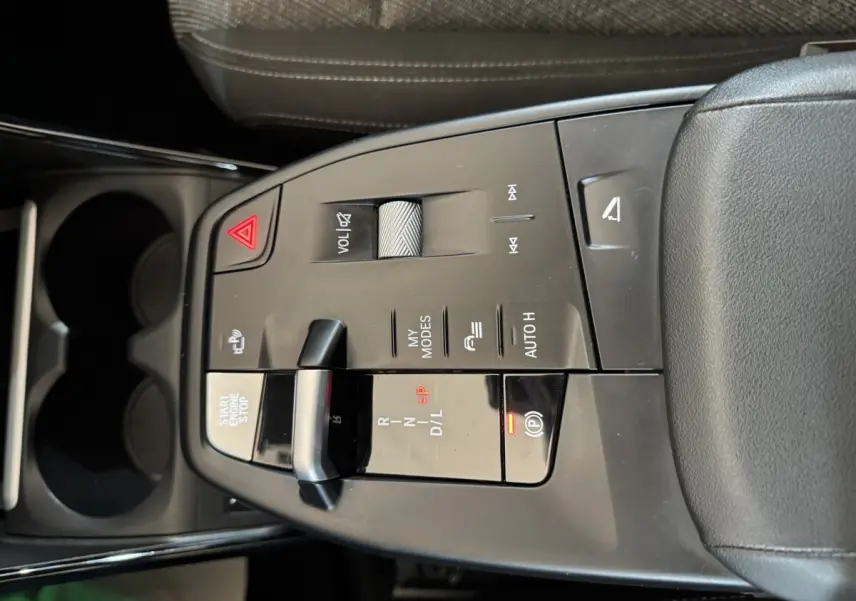 Vue en plongée sur la console centrale gris foncé du BMW X1 2024 avec commandes de boîte auto et bouton start/stop.