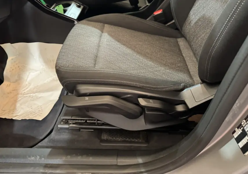Vue rapprochée du siège avant droit gris tissu de la BMW X1 sDrive20i Business Design 2024, avec commandes manuelles visibles.