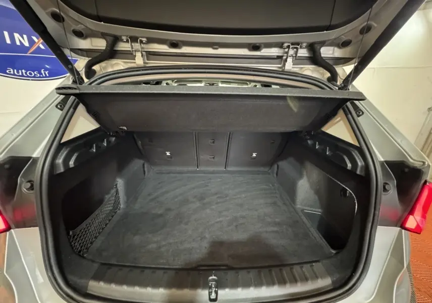 Vue arrière du coffre ouvert d’un BMW X1 gris foncé 2024, montrant un espace de chargement propre et spacieux.