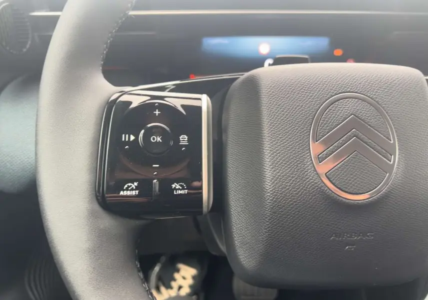 Gros plan sur le volant cuir multifonctions du Citroën C5 Aircross Hybrid 145 Plus, avec commandes de régulateur et logo Citroën.