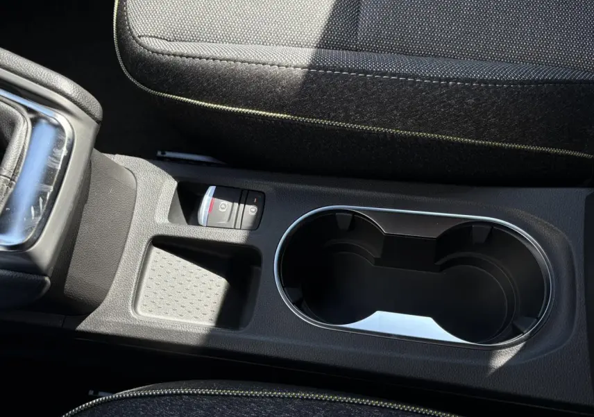 Gros plan sur la console centrale du Renault Captur 2025 avec frein de parking électrique et porte-gobelets noirs.