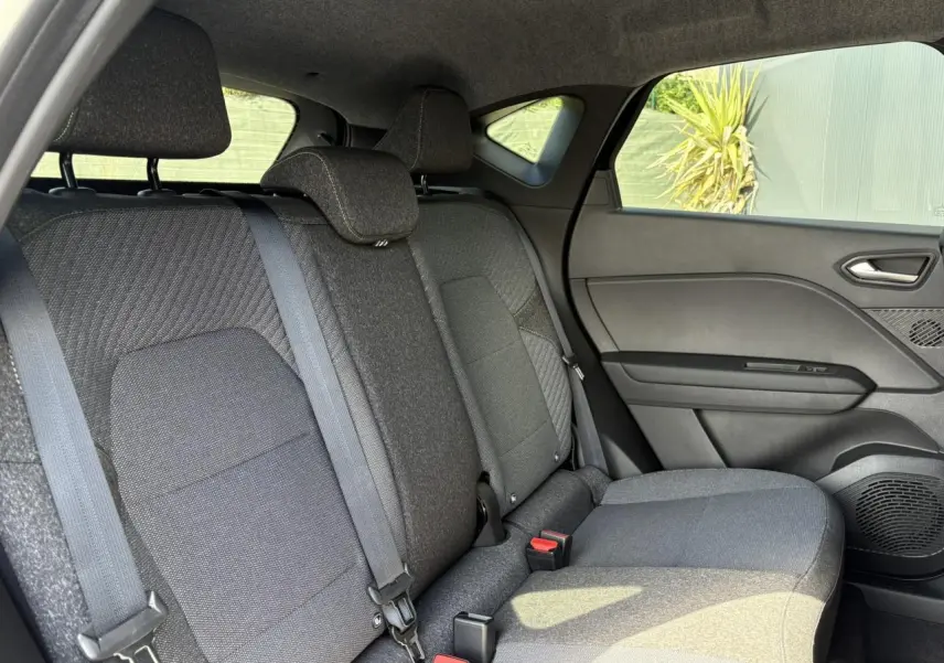 Vue intérieure côté droit de la banquette arrière grise du Renault Captur 2025 avec ceintures et appuis-tête.