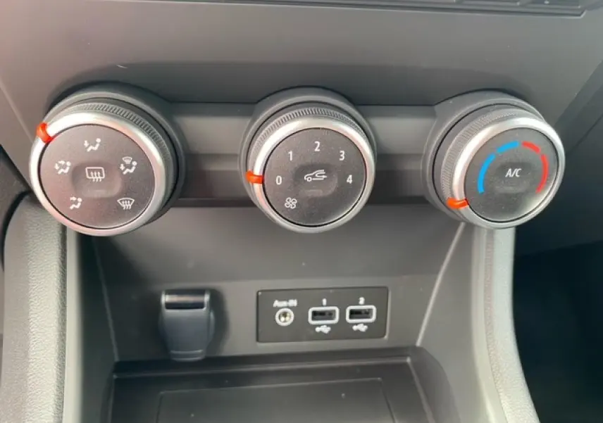 Gros plan sur les commandes de climatisation et les ports USB du tableau de bord du Renault Captur bleu 2023.