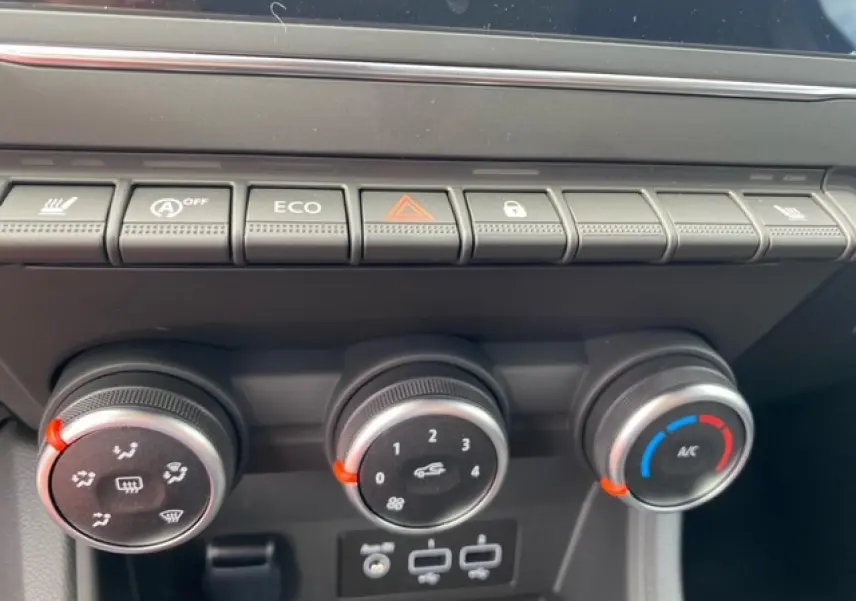 Gros plan sur les commandes de climatisation et boutons de fonction du tableau de bord du Renault Captur bleu 2023.