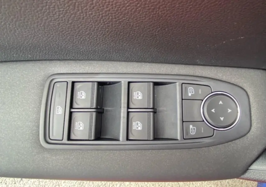 Panneau de commandes des vitres et rétroviseurs côté conducteur du Renault Captur bleu 2023 en gros plan.