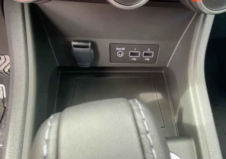 Vue rapprochée de la console centrale du Renault Captur bleu, montrant les ports USB et prise Aux-IN.