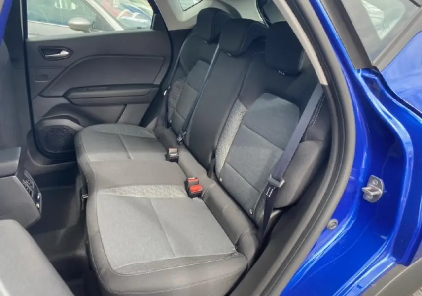 Vue intérieure arrière droite du Renault Captur bleu 2023 montrant la banquette coulissante et les ceintures de sécurité.