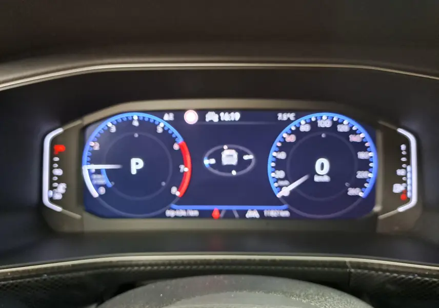 Vue rapprochée du tableau de bord numérique du Volkswagen T-Cross 2025, affichant vitesse et indicateurs en bleu et rouge.