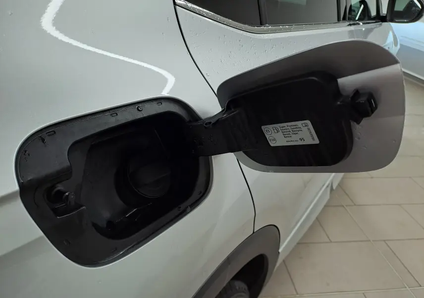 Détail de la trappe à carburant ouverte côté gauche d'un Volkswagen T-Cross 2025 Reflet d'argent, version essence.