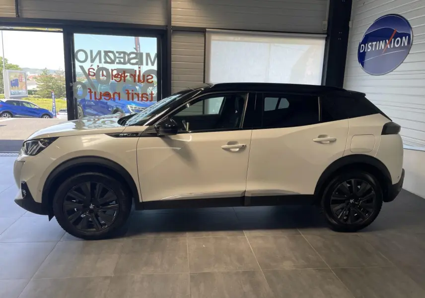 Peugeot 2008 blanc et toit noir en profil côté gauche, avec jantes noires et badge GT Line visible.