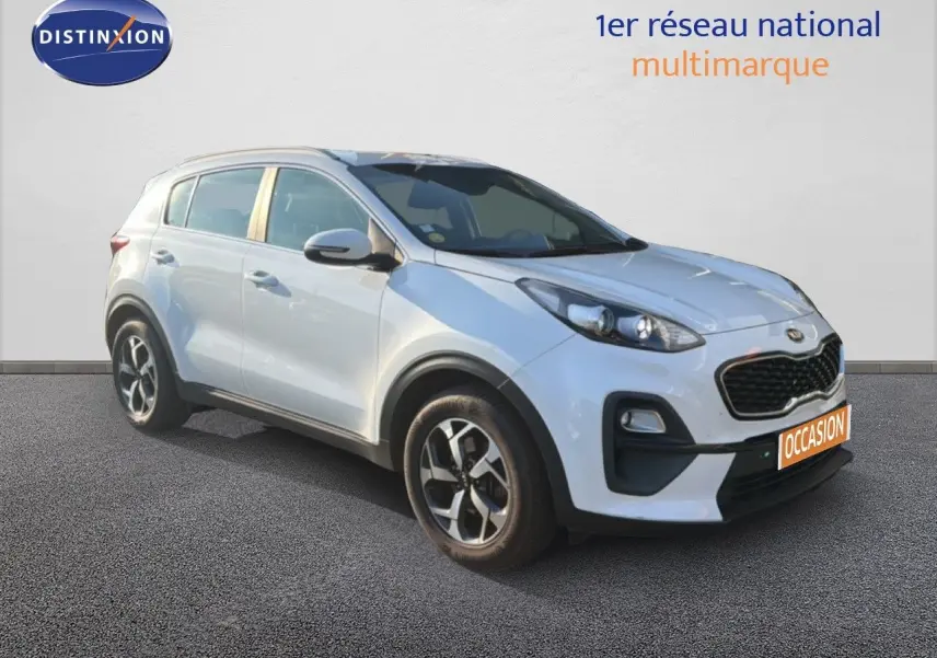 KIA Sportage blanc nacré métal en 3/4 avant droit, avec calandre noire et jantes alliage bicolores.