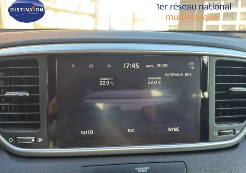 Écran tactile central du tableau de bord du Kia Sportage 2021, affichant la climatisation à 22°C, entouré de grilles d'aération noires.