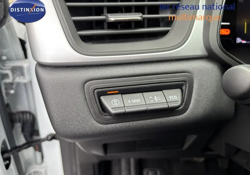 Gros plan sur les commandes E-SAVE et ECO du tableau de bord d’un Renault Symbioz blanc nacré, côté gauche.