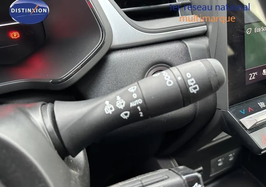 Gros plan sur la commande d’essuie-glace à gauche du volant dans l’habitacle du Renault Symbioz blanc nacré.