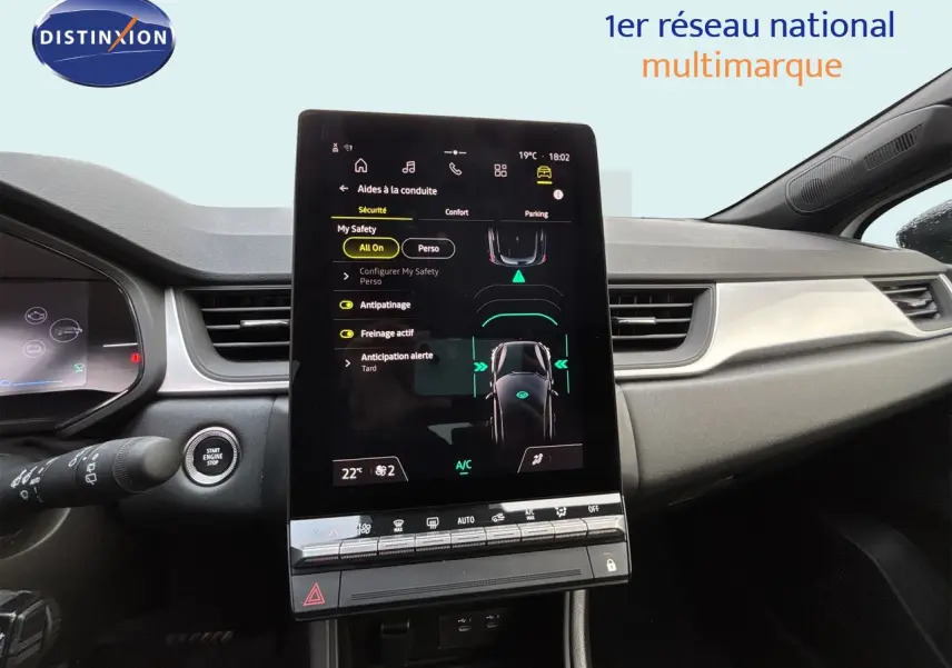 Vue intérieure du tableau de bord de la Renault Symbioz blanc nacré, avec écran tactile central vertical et commandes digitales.