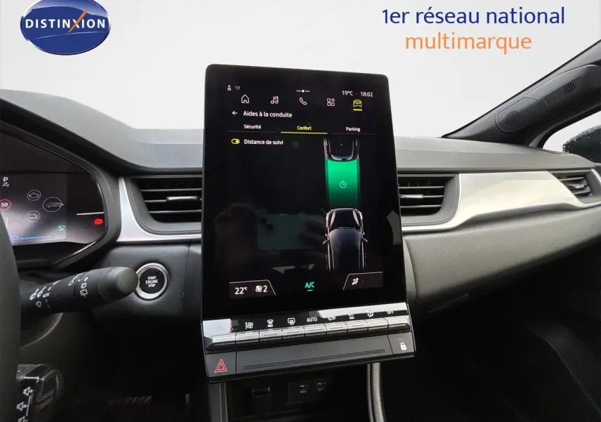Vue intérieure du tableau de bord de la Renault Symbioz blanc nacré, avec écran tactile central vertical et commandes climatisation.