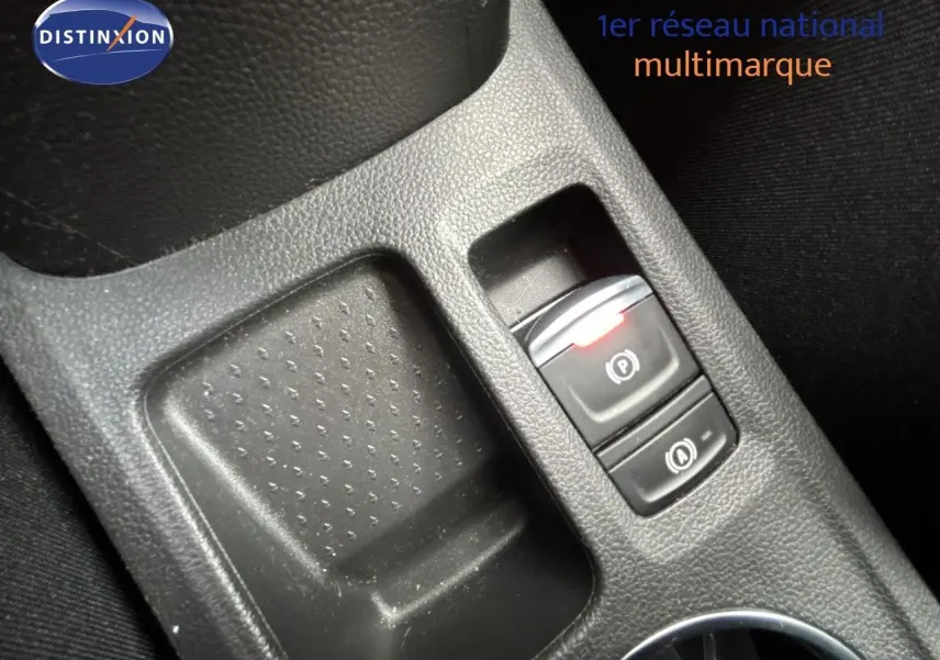 Gros plan sur la console centrale noire avec bouton frein à main électronique et fonction auto hold, intérieur tissu noir.