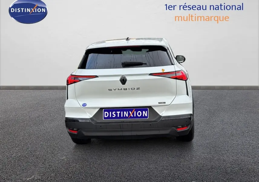 Vue arrière d'une Renault SYMBIOZ blanc nacré métal, avec feux arrière fins et logo central visible.