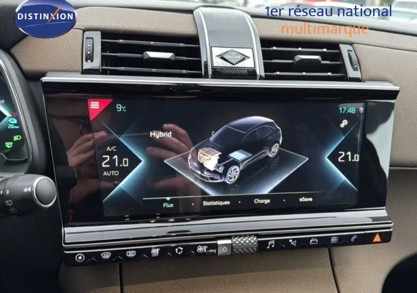 Écran tactile central du DS7 Crossback bleu encre métal, affichant les informations hybrides et climatisation à 21°C.