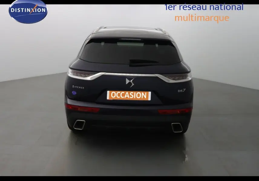 Vue arrière d'un DS7 Crossback bleu encre métal avec logo DS et badges E-TENSE et DS7 visibles.