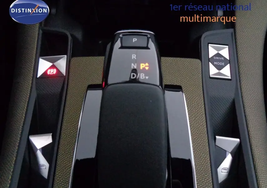 Gros plan sur la console centrale du DS7 Crossback bleu encre, montrant le levier de vitesse automatique et les boutons de mode de conduite.