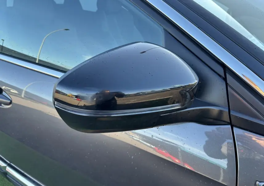 Rétroviseur côté gauche noir brillant du Peugeot 3008 gris métal, version GT Line 2020, avec gouttes d'eau visibles.