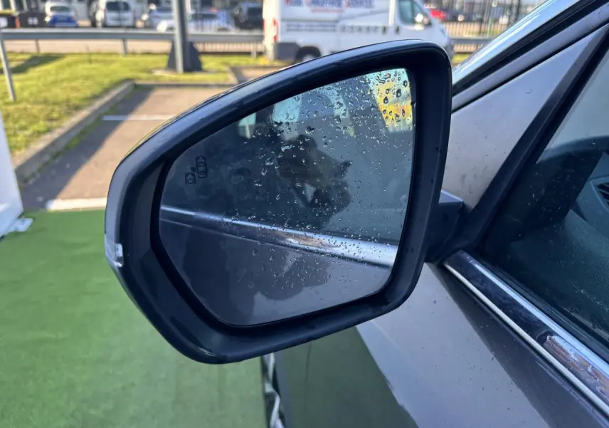 Rétroviseur côté gauche d'un Peugeot 3008 gris métal 2020 avec gouttes d'eau sur le miroir et carrosserie visible.