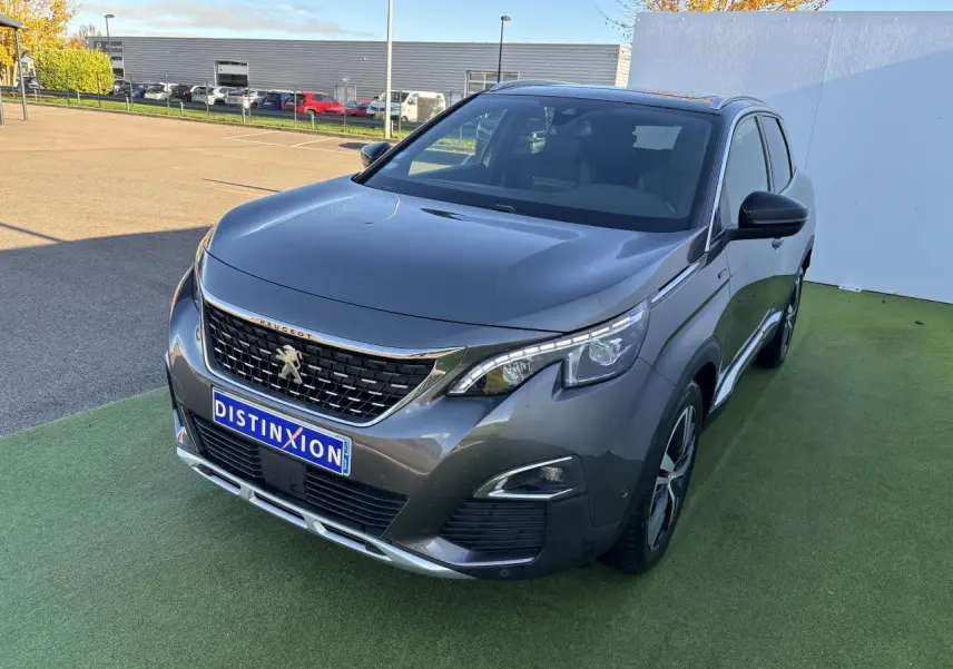 Peugeot 3008 gris métal vue 3/4 avant droit, avec calandre chromée et phares LED distinctifs.