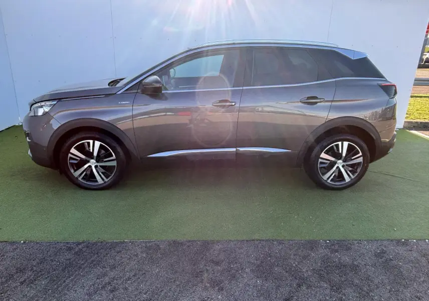 Profil côté gauche d'un Peugeot 3008 gris métal 2020 GT Line avec jantes alliage et toit noir.