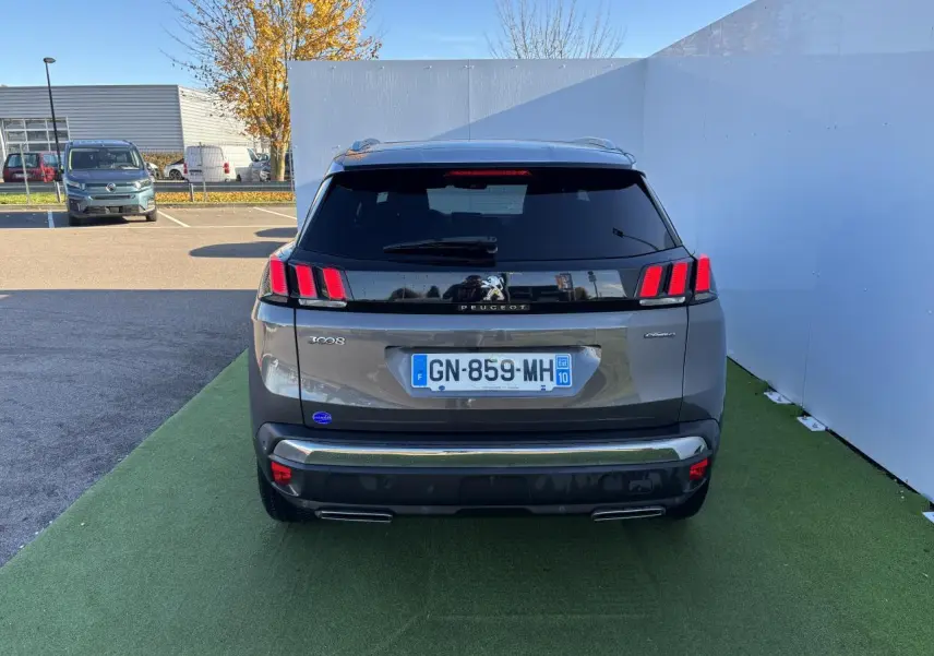 Vue arrière d'un Peugeot 3008 gris métal de 2020, avec feux arrière à trois griffes rouges caractéristiques.