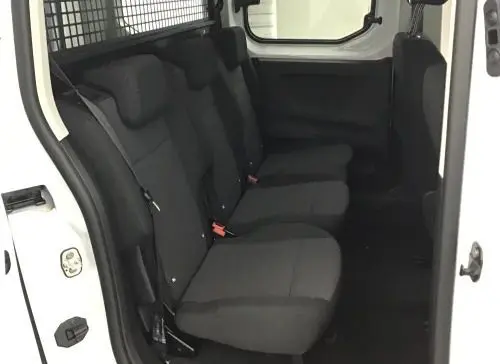 Vue intérieure côté droit du Peugeot Rifter blanc banquise 2025, montrant les sièges arrière noirs et la cloison métallique.