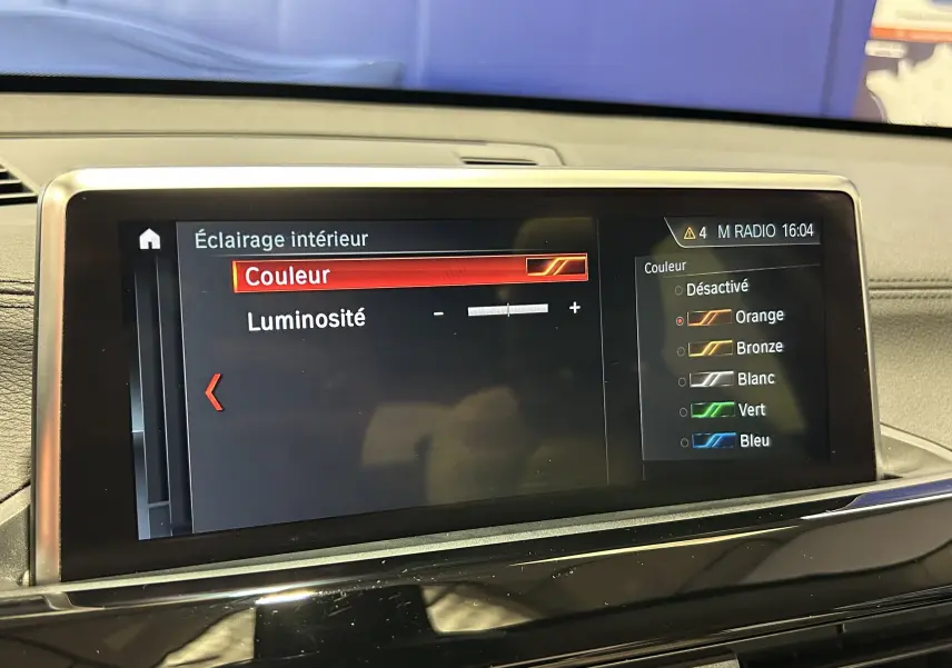 Écran central de BMW X1 2019 affichant le réglage de l’éclairage intérieur avec sélection de couleur orange.