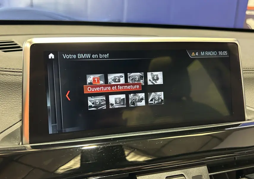 Écran central de la BMW X1 2019 affichant le menu "Ouverture et fermeture" avec tableau de bord noir et finitions chrome.
