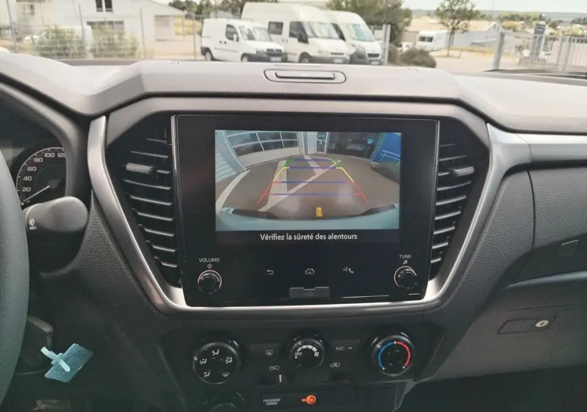 Vue intérieure du tableau de bord de l'Isuzu D-MAX 2026 avec écran de caméra de recul affiché.