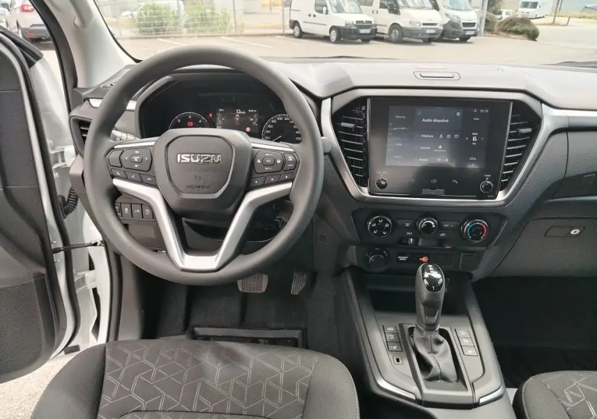 Vue intérieure avant de l'Isuzu D-MAX 2026, tableau de bord avec volant multifonction et écran tactile central.